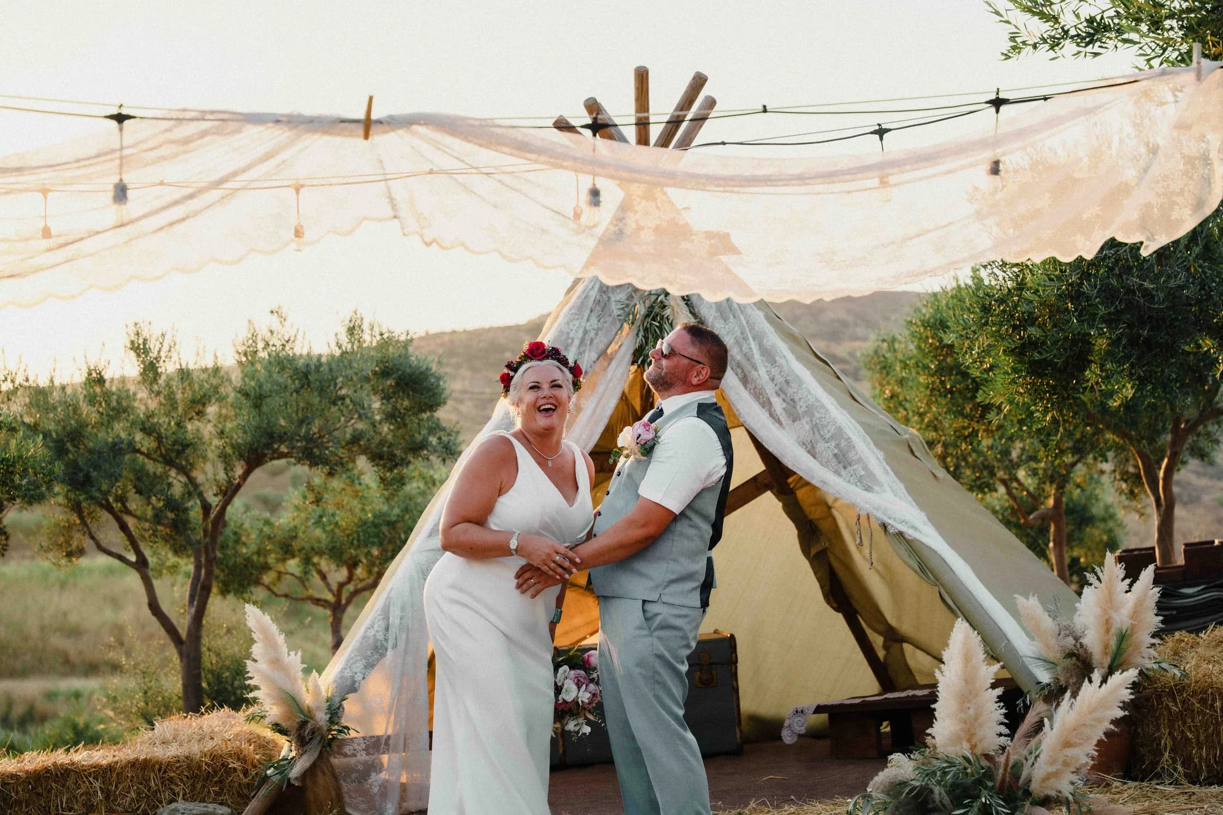 A couple kissing beneath the linen tent at Moresca Farm in low golden light