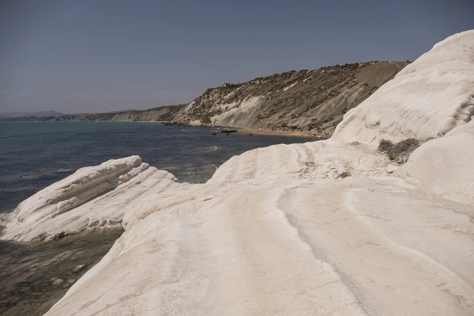 The white chalk cliffs of Punta Bianca dropping into clear sea
